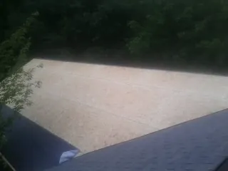 New OSB roof sheathing installed beside an existing shingle roof in Highland Park