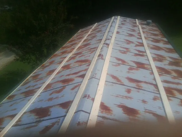 Rusted metal roof panels with new wood purlins before replacement — Storm Damage Roof Repair in Highland Park by Roofing Brothers