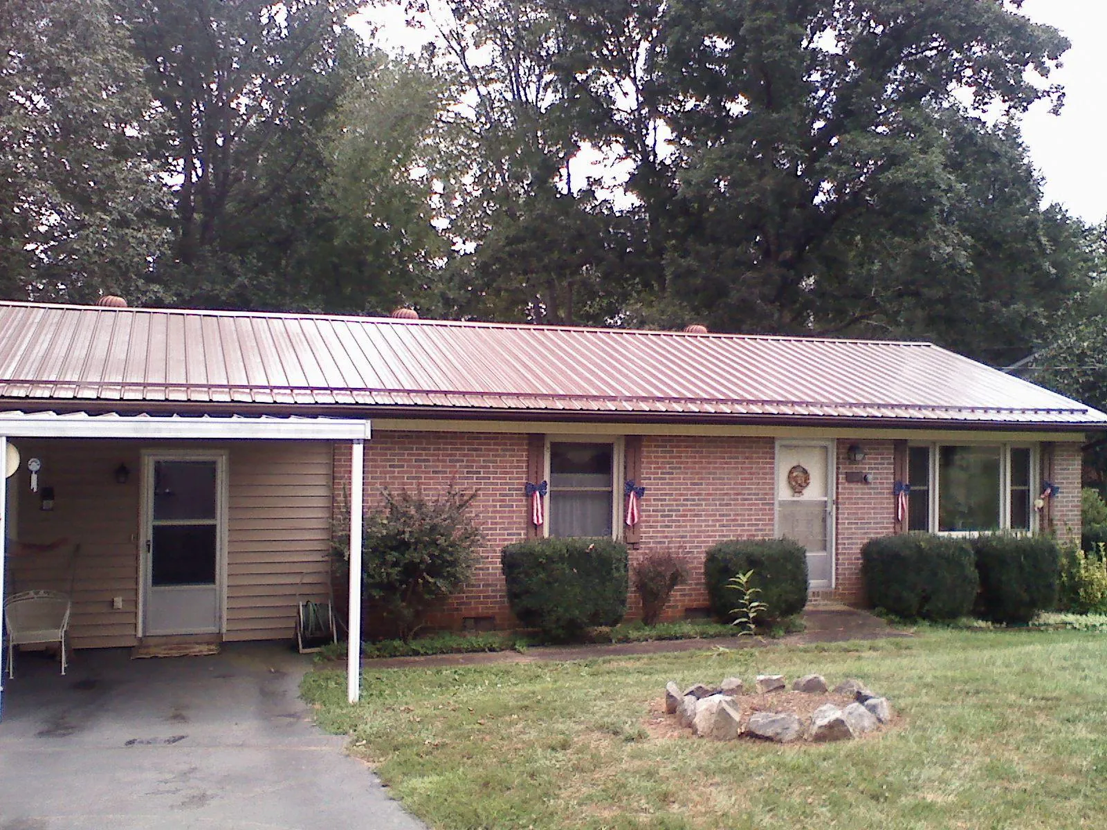 Bronze metal roof and carport on a brick ranch home — Roof Repair work by our crew in Highland Park