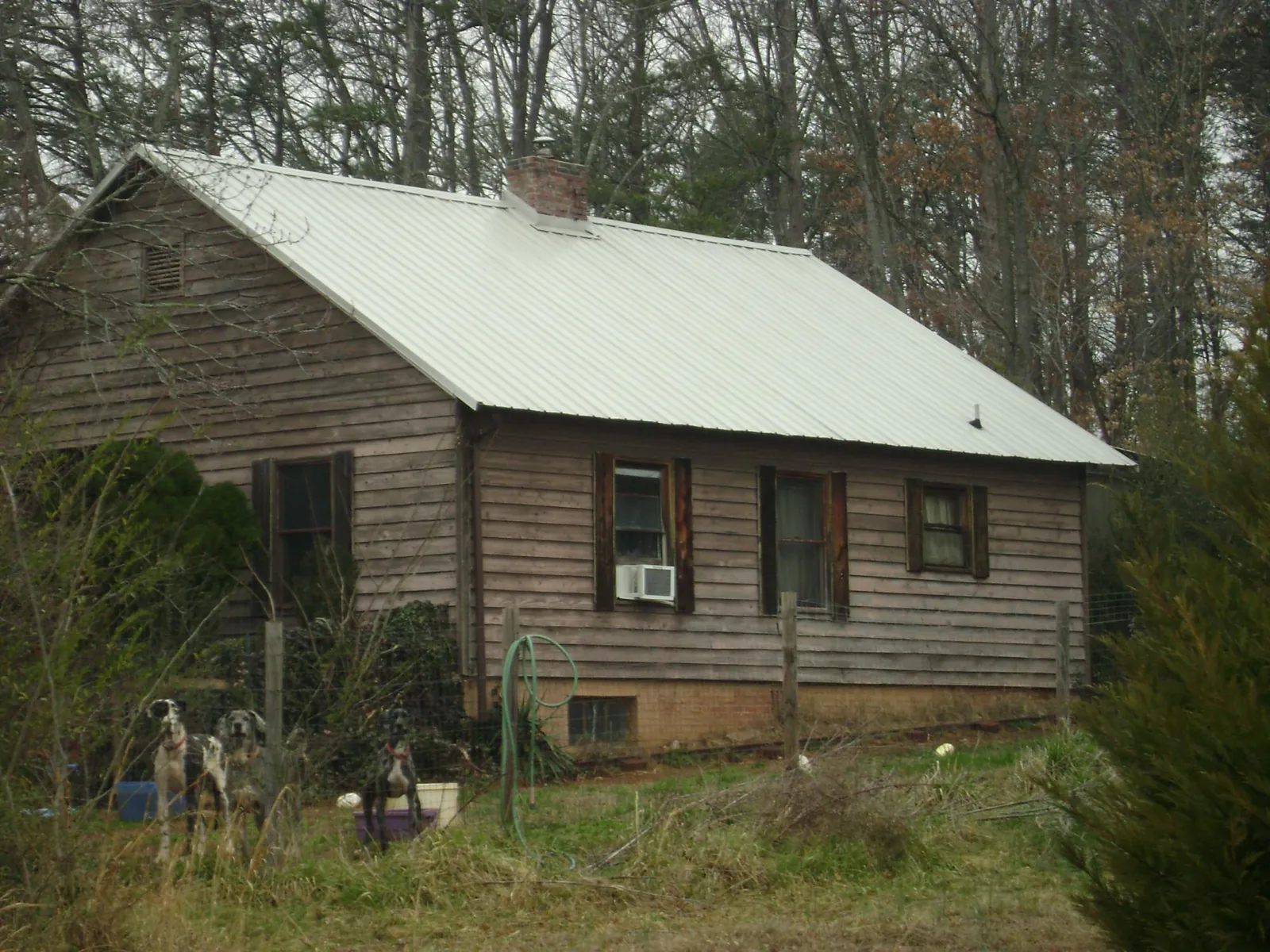 White metal roof on an old wood sided farmhouse, from a Asphalt Shingle Roof Repair job in Highland Park